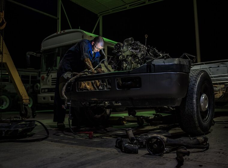 Araç motorunda bakım yapan teknisyen